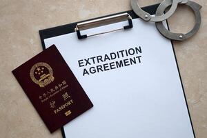 Passport of China Republic and Extradition Agreement with handcuffs on table photo
