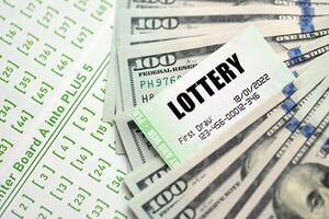 Green lottery tickets and US money bills on blank with numbers for playing lottery photo