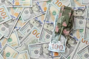 Tank on crumpled hundred dollar bills banknotes. Background of war funding and military support photo