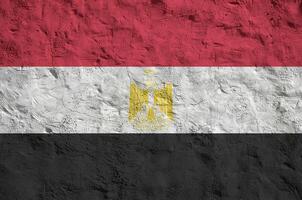 Egypt flag depicted in bright paint colors on old relief plastering wall. Textured banner on rough background photo