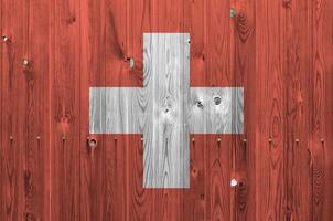 Switzerland flag depicted in bright paint colors on old wooden wall. Textured banner on rough background photo