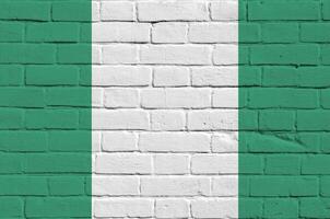 Nigeria flag depicted in paint colors on old brick wall. Textured banner on big brick wall masonry background photo