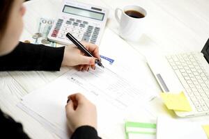 Accountant fill American tax form W-2 Wage and Tax Statement in end of tax period. Taxation and paperwork routine photo
