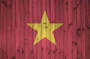 Vietnam flag depicted in bright paint colors on old wooden wall. Textured banner on rough background photo