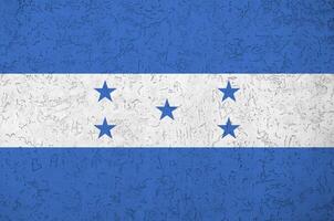 Honduras flag depicted in bright paint colors on old relief plastering wall. Textured banner on rough background photo