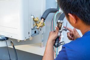 Male technician installing outdoor unit of air conditioner to cool the household in the summer. air compressor, electronic, photo