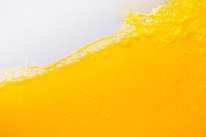 Close up bright orange juice splash texture for health and nature waves, Beautiful waves curve and little bubbles smooth for garphic design and background photo