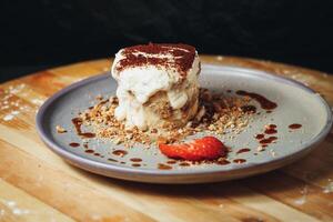 Delectable Tiramisu Served on a Ceramic Plate Garnished With Strawberry and Cocoa photo