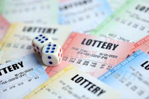 Many lottery tickets and dice on blank bills with numbers for playing lottery photo
