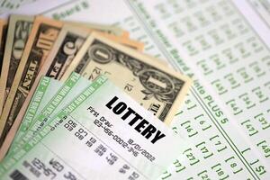 Green lottery tickets and US money bills on blank with numbers for playing lottery photo