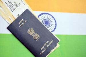 Blue Indian passport with airline tickets on flag background close up photo