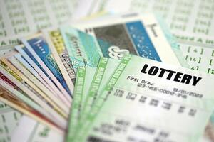 Green lottery tickets and iranian money bills on blank with numbers for playing lottery photo