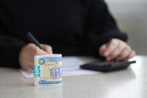 Accountant start to fill Iranian tax form on office table. Taxation period and annual taxpayers routine photo