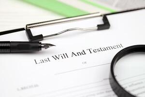 Last Will and testament blank document on A4 tablet lies on office table with pen and magnifying glass photo