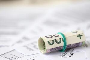 Polish zloty money on big amount of polish tax forms close up. Accounting, bureaucracy and taxpayers routine photo