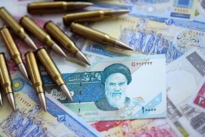 Many bullets and iranian rials money bills close up. Concept of terrorism funding or financial operations to support war photo