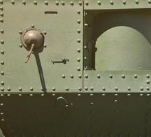 The texture of the wall of the tank, made of metal and reinforced with a multitude of bolts and rivets. Images of the covering of a combat vehicle from the Second World War with a guided machine gun photo