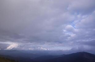 Morning view from the Dragobrat mountain peaks in Carpathian mountains, Ukraine. Cloudy and foggy landscape around Drahobrat Peaks photo