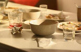 Empty dirty plates with spoons and forks on the table after meal. Banquet ending concept. Unwashed dishes photo