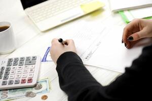 Accountant fill American tax form W-2 Wage and Tax Statement in end of tax period. Taxation and paperwork routine photo