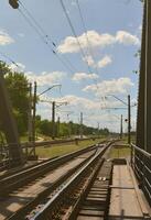Summer day railway landscape with a view from the railway bridge to the suburban passenger station photo