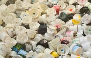 A pattern of many used and soiled nozzles from spray cans with aerosol paint. Background texture of the street art of drawing graffiti on the walls photo