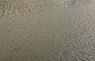 The texture of dark river water under the influence of wind, imprinted in perspective. Horizontal image photo