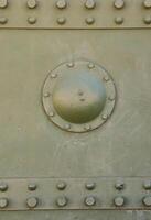 The texture of the wall of the tank, made of metal and reinforced with a multitude of bolts and rivets. Images of the covering of a combat vehicle from the Second World War photo