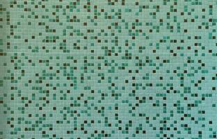 The texture of the wall, decorated with a mosaic of various small square tiles. Abstract pattern of ceramic tiles on the wall photo