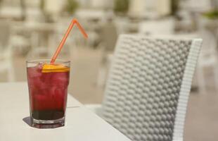 Pink and red Fresh colorful exotic alcoholic cocktail with lemon and ice on restaurant table. Colorful pink Soft drink with ice photo