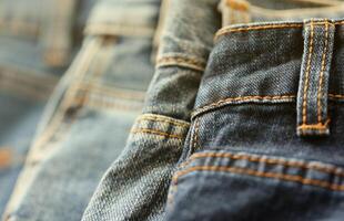 Many jeans in stack in wardrobe room. Row of pants denim jeans in closet. Concept of buy, sell, shopping and fashionable clothes photo