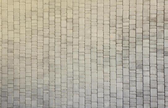 Gray color paving slabs in the pedestrian street sidewalk. Rough cobblestone pattern with many square shaped stones photo