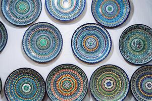 Uzbek handmade ceramic plates with hand-painted ethnic Oriental colorful patterns in tableware store photo