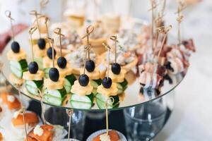 canapes with olives, cheese, cucumber and red fish for a delicious appetizer photo