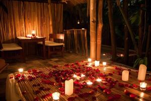 Romantic dinner setup with candles and rose petals photo