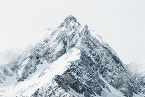 Snow-covered mountain peak against a soft transparent white surface, ideal for snowy landscapes photo