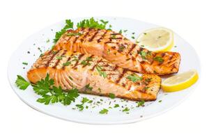 A plate of grilled salmon with lemon and herbs on a transparent white surface photo