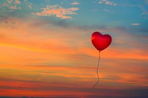 Single red heart-shaped balloon floating against a romantic sunset sky, great for Valentine's Day photo