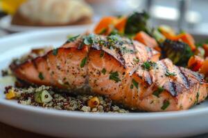 Plate of grilled salmon with quinoa and roasted vegetables, a nutritious dinner choice photo