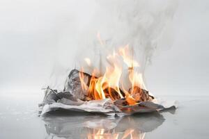 Burning paper engulfed in flames against a transparent white surface, symbolizing destruction and transformation photo