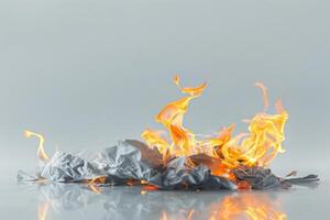 Burning paper engulfed in flames against a transparent white background, symbolizing destruction and transformation photo