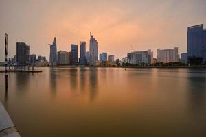 Ho Chi Minh City skyline and the Saigon River. Amazing colorful night view of skyscraper and other modern buildings at downtown. Travel concept photo