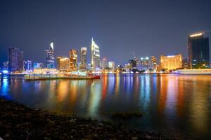 Ho Chi Minh City skyline and the Saigon River. Amazing colorful night view of skyscraper and other modern buildings at downtown. Travel concept photo