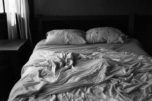 Empty bed with rumpled sheets, symbolizing the restlessness of insomnia photo