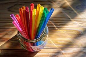Rainbow-colored paper straws transparently arranged in a glass jar photo