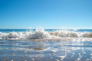 Sparkling ocean waves crashing against a sandy beach under a clear blue sky photo