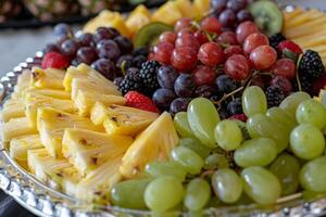Close-up of a colorful fruit platter with pineapple, grapes, kiwi, and berries, a nutritious and refreshing snack photo