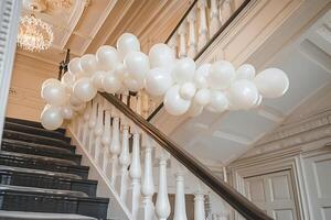 Elegant balloon garland draped across a staircase railing, adding flair to a wedding venue photo