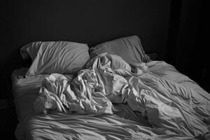 Empty bed with tousled sheets, showing the restless movements of insomnia photo