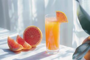Zesty grapefruit juice in a glass with grapefruit slices on a transparent white surface, tangy and refreshing photo